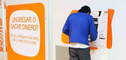 Una persona saca dinero de un cajero en una oficina de ING.