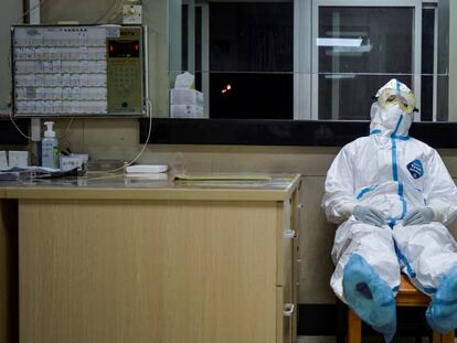 Un trabajador médico se toma un descanso en un área aislada de un hospital de Wuhan. 