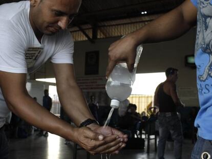 People wash their hands with disinfectant at a Havana bus stop on Tuesday.