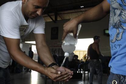 People wash their hands with disinfectant at a Havana bus stop on Tuesday.