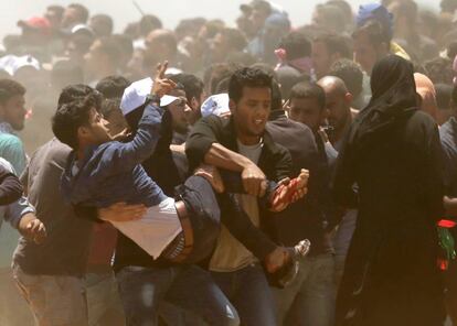 Varias personas trasladan a un herido durante la protesta en la frontera entre Gaza e Israel, el 14 de mayo de 2018.