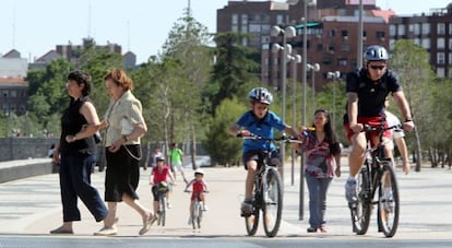 Cyclists mingle with pedestrians in the Madrid R&iacute;o park in the capital. But should all bike users have to wear helmets?