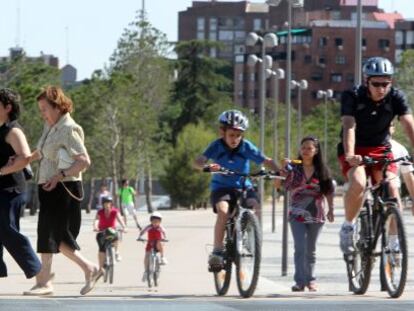 Cyclists mingle with pedestrians in the Madrid R&iacute;o park in the capital. But should all bike users have to wear helmets?
