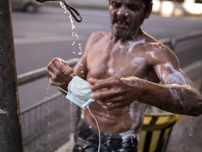 Morador de rua lava máscara em torneira improvisada em São Paulo, na última terça-feira. ANDRÉ LUCAS /