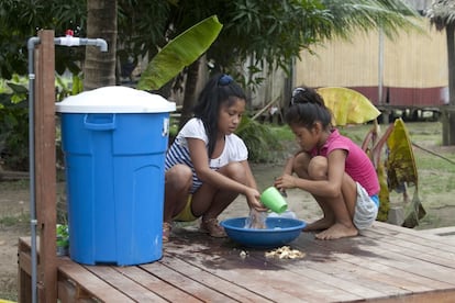 Dos niñas de la comunidad shipiba de Santa Rosita de Abujau, en la región peruana de Ucayali, se lavan las manos en un sistema de saneamiento ecológico.