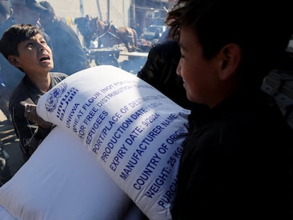 Palestinians gather to receive bags of flour distributed by the United Nations Relief and Works Agency (UNRWA), amid the ongoing conflict between Israel and Palestinian Islamist group Hamas, in Rafah in the southern Gaza Strip February 1, 2024. REUTERS/Ibraheem Abu Mustafa