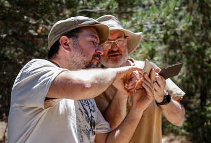 El profesor de la UAM Jesús Marugán observa una laja junto a José Luis Sañudo, uno de los voluntarios asiduos a la investigación en Las Hoyas desde el año 1989.