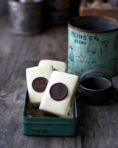 <p><b>Ingredientes</b> (para 10 unidades)</p><p>1 paquete de obleas para helado rectangulares (20 láminas), 200 gramos de crema de cacao y avellanas (tipo Nutella o Nocilla).</p><p>Para la cobertura de chocolate blanco: 300 gramos de chocolate blanco, 30 gramos de manteca de cacao (opcional).</p><p>Para los lacres de chocolate negro: 150 gramos de chocolate negro (70% de cacao), sellos para lacre metálicos.</p><p><b>Preparación</b></p><p> Preparar los lacres de chocolate poniendo los sellos metálicos en el congelador. Fundir el chocolate y atemperarlo. Sobre una bandeja forrada con papel de hornear, depositar media cucharadita de chocolate templado. Sacar el sello del congelador, colocarlo sobre el chocolate y dejarlo unos segundos. Al retirarlo deberá salir limpiamente; dejar que se solidifique el chocolate en un lugar fresco. Repetir el proceso hasta tener los lacres de chocolate necesarios y reservarlos. Con un cuchillo, untar una capa de crema de cacao y avellanas en las obleas de helado y pegarlas de cuatro en cuatro. Guardar en el frigorífico dos horas para que luego sea más fácil cortarlas. Pasado este tiempo, fundir el chocolate blanco con la manteca de cacao, atemperar y cortar en dos cada galleta grande, para obtener dos rectángulos. Bañar cada mitad en el chocolate, escurrir bien y depositar sobre papel de hornear. Antes de que solidifique por completo, colocar un lacre encima a modo de decoración. Se conservan varios días en un recipiente hermético en un lugar fresco.</p>