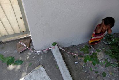 Shavani, junto a la piedra a la que permanece atado. Sus padres se dedican a cavar agujeros para los cables de electricidad en la ciudad de Ahmedabad.