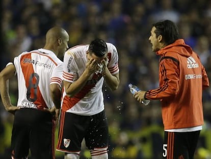 Um jogador de River lava-se depois de ser atacado com gás pimenta.