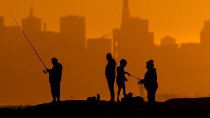 Personas pescan al atardecer en Alameda (California), el 1 de julio.