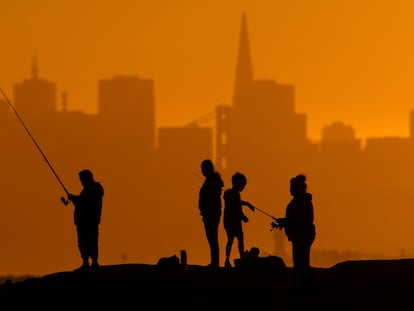 Personas pescan al atardecer en Alameda (California), el 1 de julio.
