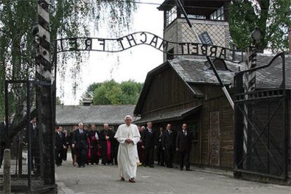 El Papa cruza la puerta del campo de concentración bajo la lúgubre frase <i>El trabajo te hará libre</i>.