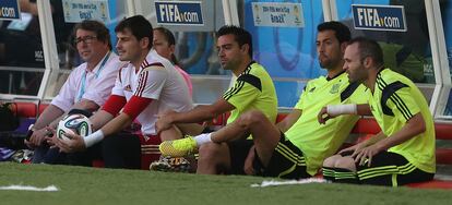 Casillas, Xavi, Busquets e Iniesta observan el entrenamiento sentados en el banquillo.