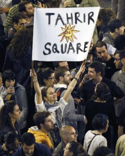 Una manifestante muestra una pancarta con referencias a las protestas en Egipto.