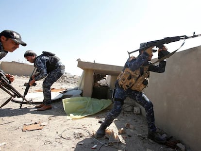 Un pollic&iacute;a federal iraqu&iacute; dispara su rifle en un distrito de la ciudad vieja de Mosul, este domingo