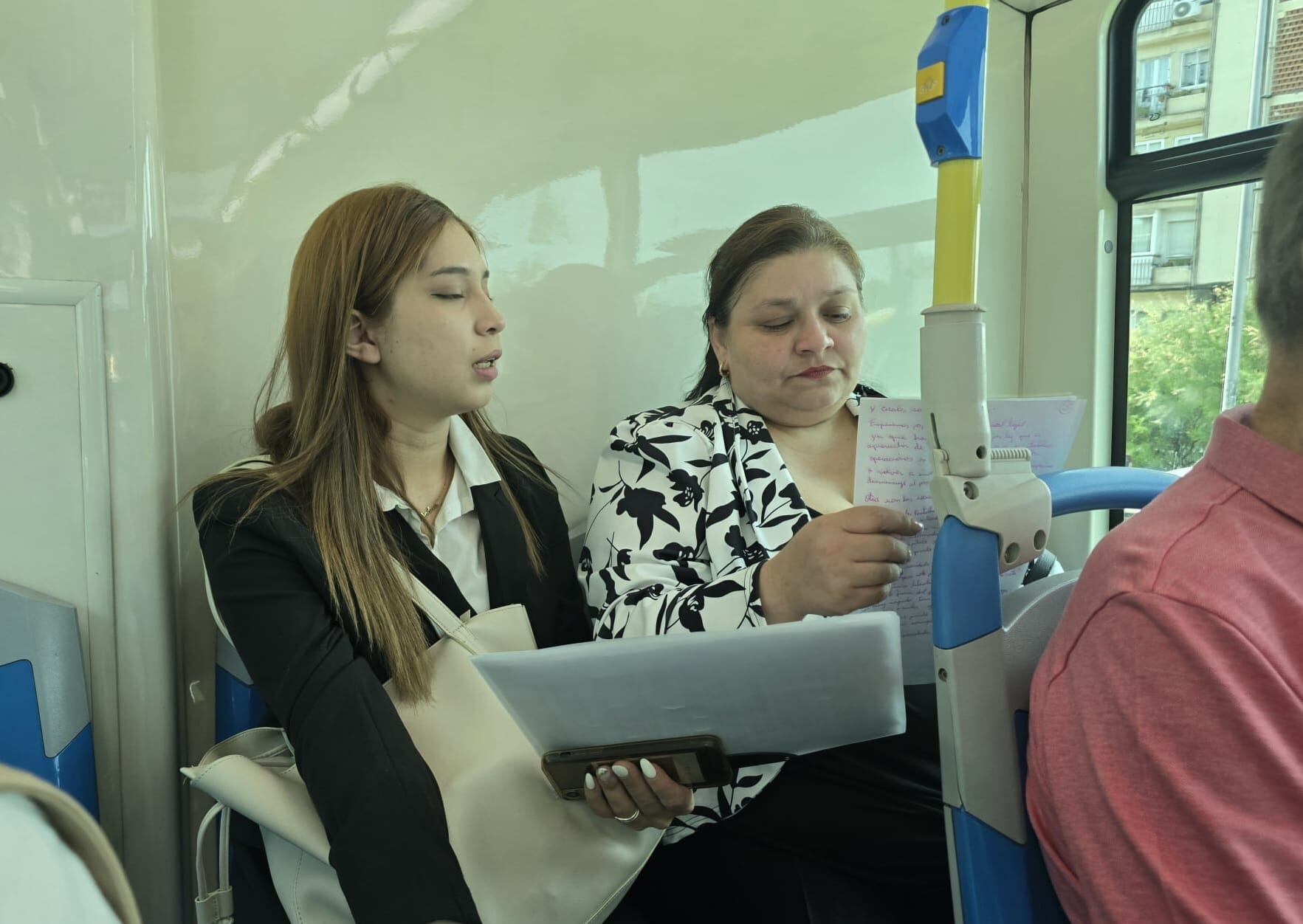 Andrea Torres y María Rosa López repasan sus apuntes en el autobús, camino de su prueba final.