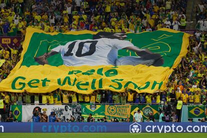 Hinchas de Brasil animan con una bandera con la imagen del astro brasileño Pelé hoy, en un partido de los octavos de final del Mundial de Fútbol Qatar 2022 entre Brasil y Corea del Sur en el estadio 974 en Doha (Catar). 