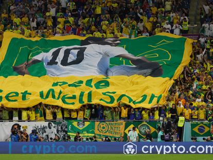 GR1372. DOHA (CATAR), 05/12/2022.- Hinchas de Brasil animan con una bandera con la imagen del astro brasileño Pelé hoy, en un partido de los octavos de final del Mundial de Fútbol Qatar 2022 entre Brasil y Corea del Sur en el estadio 974 en Doha (Catar). EFE/ JJ Guillén
