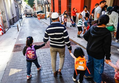 Un padre lleva a sus hijos al Colegio Antonio Moreno Rosales, este lunes.