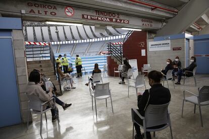 Varias personas esperan en el "vacunómetro" de San Sebastián puesto en marcha de manera experimental en la plaza de toros de Illumbe.