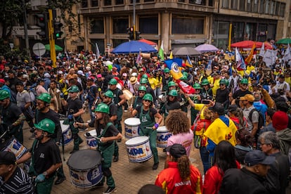 Un grupo de artistas toca instrumentos de percusión mientras avanza por el centro de Bogotá. 