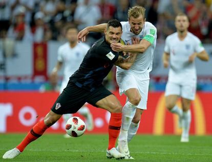 Dejan Lovren carga contra Harry Kane en la lucha por un balón.