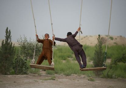 Dos niños afganos juegan en los columpios a las afueras de la ciudad afgana de Mazar-i-Sharif.