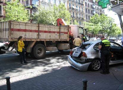 Un agente de la Policía Municipal revisa el vehículo arrastrado por el camión grúa.