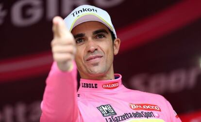 Contador, en el podio de Valdobbiadene, hace el gesto del pistolero con la maglia rosa rescuperada.