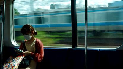 Una mujer mirando su teléfono en un tren de Tokio, este sábado.