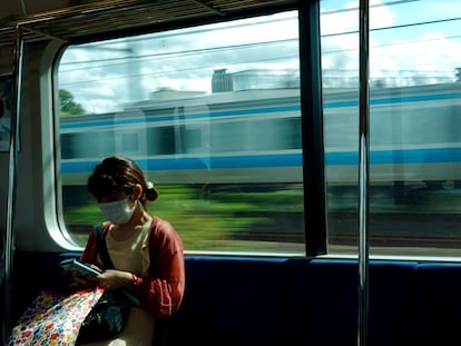 Una mujer mirando su teléfono en un tren de Tokio, este sábado.