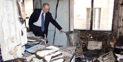 El presidente de la Audiencia de Alicante, Vicente Magro, muestra los desperfectos causados por el fuego.