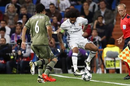 El centrocampista brasileño del Legia Varsovia, Guilherme (i), intenta evitar el avance de su compatriota, el defensa del Real Madrid, Marcelo Vieira (d), durante el partido de Liga de Campeones disputado en el estadio Santiago Bernabéu.