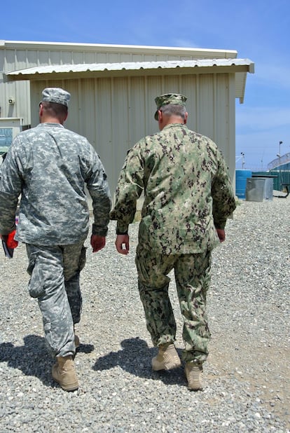 Dos miembros del Ejército de EEUU escoltan a mimebros de la prensa en su visita al centro médico donde son tratados los reos y se les practican las alimentaciones forzosas.