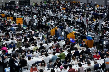 Funcionarios de la Comisión Electoral Nacional de Corea del Sur clasifican las papeletas de los comicios locales para elegir alcaldes, gobernadores, miembros del consejo y superintendentes de educación en todo el país, este miércoles, en un gimnasio en Seúl.