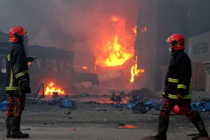 Bomberos trabajan tras la explosión del almacén de contenedores en Sitakunda, este domingo. 