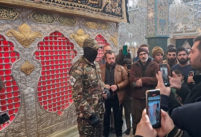 La gente toma fotos de un combatiente rebelde frente a la tumba de Zeinab ben Ali, nieta de Mahoma, en la ciudad siria de Saida Zeinab, este miércoles.