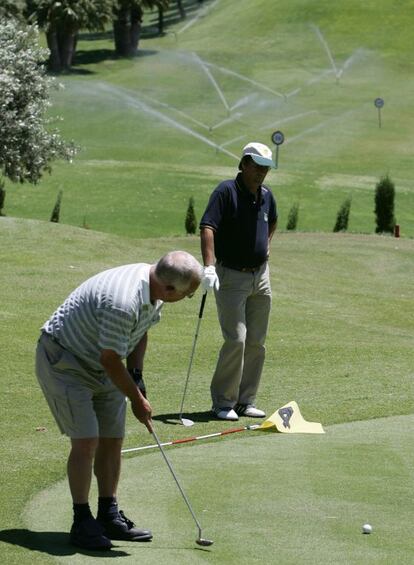 Dos jugadores practican en un campo de golf.