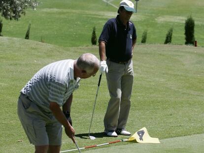 Dos jugadores practican en un campo de golf.