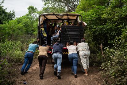 Profesores y ayudantes empujan un camión escolar averiado en una carretera rural que conduce a la escuela La Voluntad de Dios, en Paraguachón, el 22 de noviembre de 2023.