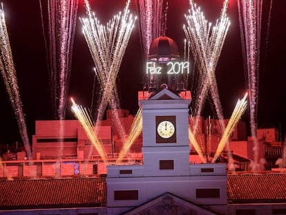 El reloj de la Puerta del Sol da las campanadas de fin de año, frente a la mirada de miles de personas.