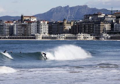 Un surfista aprovecha las óptimas condiciones para practicar este deporte hoy en la bahía de La Concha de San Sebastián, donde se aproxima un fuerte temporal de mar. 