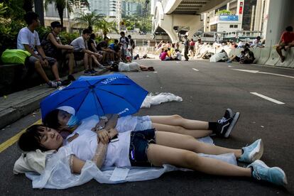 Unas jóvenes descansan en la zona ocupada frente a la sede del gobierno en Hong Kong.