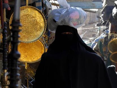 Una mujer con burka hace la compra en un mercado. 