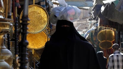 Una mujer con burka hace la compra en un mercado. 