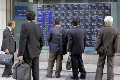 Inversores japoneses observan un panel con cotizaciones.