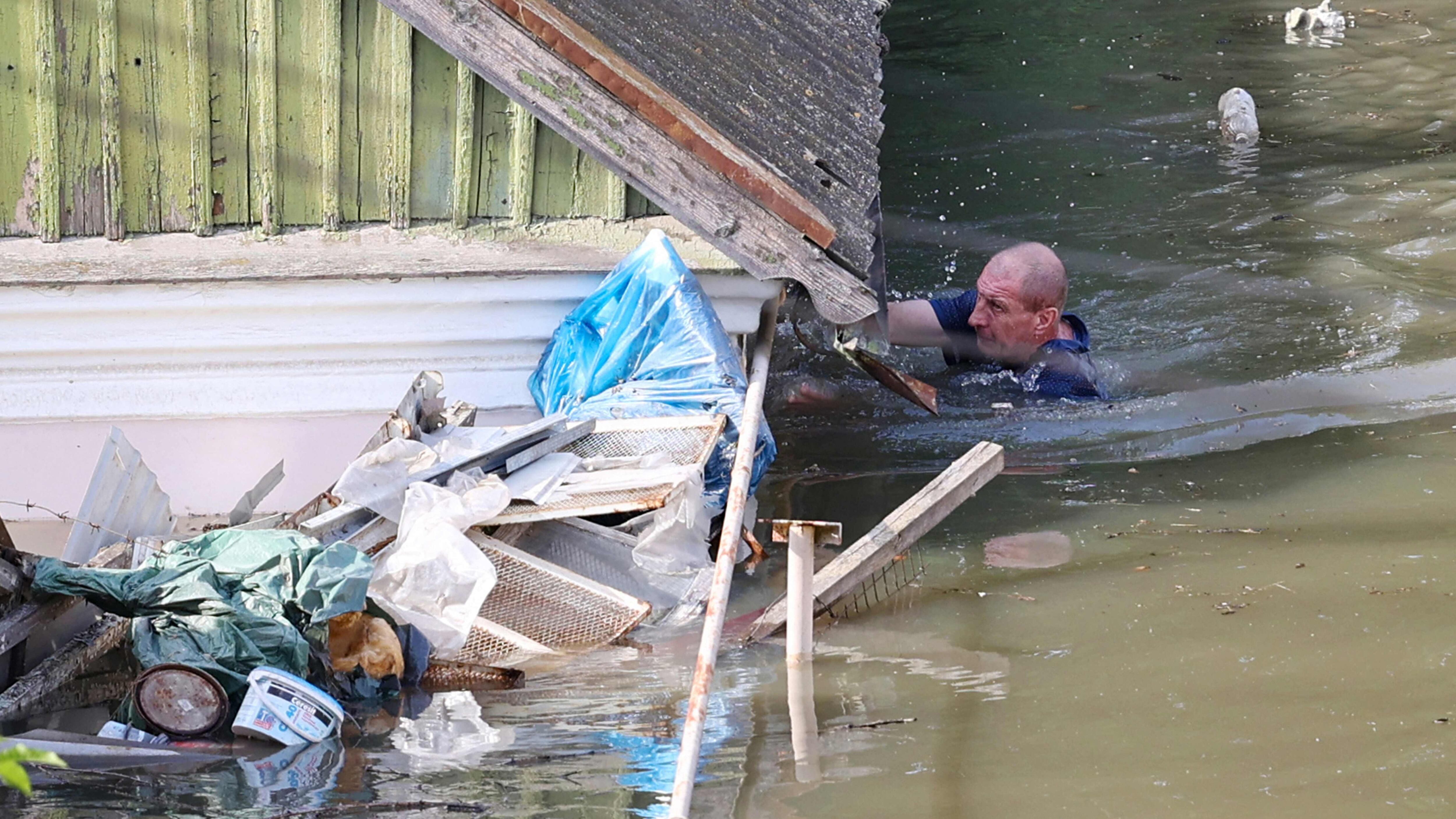 Un vecino nada junto a una casa inundada en Jersón, este miércoles.  