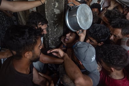 Cientos de palestinos desplazados se reúnen frente a un comedor social en la ciudad de Gaza, este domingo.