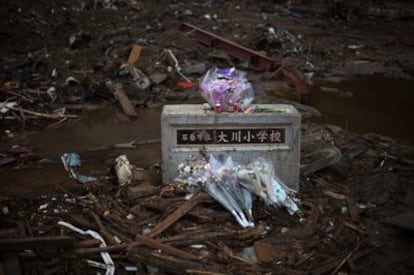 Varios ramos de flores descansan sobre las ruinas del lugar donde antes estaba la escuela elemental Okawa, en Ishinomaki, Miyagi. Según los últimos datos, 13.116 personas han muerto hasta la fecha por el terremoto y posterior tsunami.